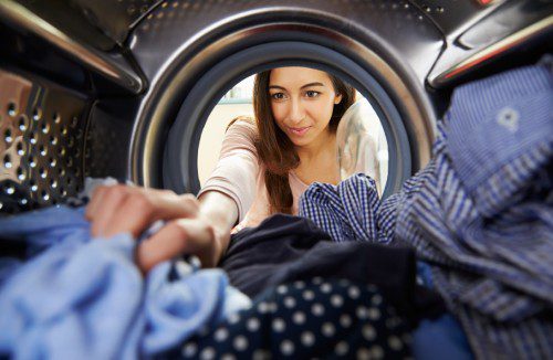 WomanGrabbingClothersFromDryer